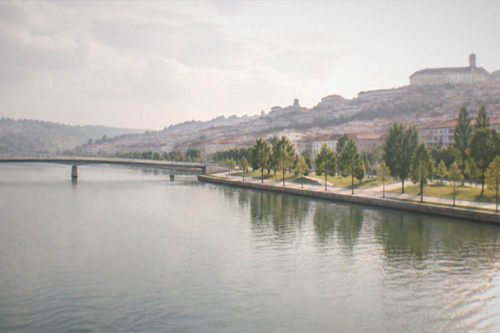 The wide River Mondego seen from a bridge with the Santa Clara riverbank and park beyond