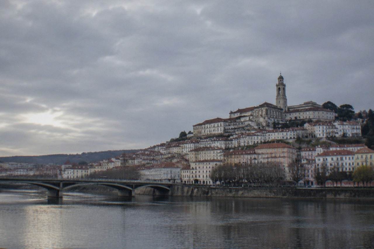 The old city of Coimbra rising above the River Mondego, with the university tower on the hilltop