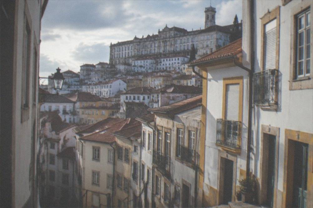 The grand baroque facade of the university buildings on the hilltop above the old town rooftops