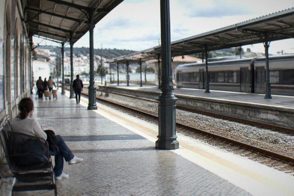 A railway station concourse with departure boards and passengers with luggage