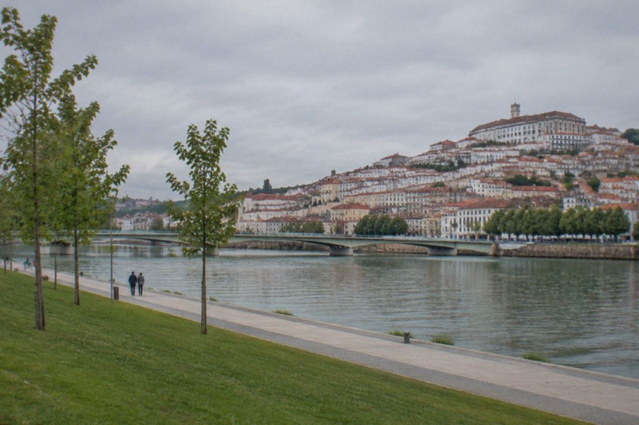 View over the red rooftops of Coimbra with the River Mondego in the foreground