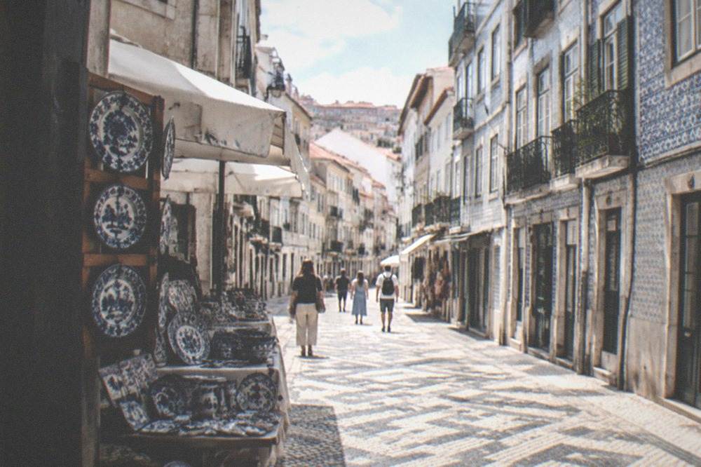Hand-painted ceramic plates in blue and white displayed on a market craft stall