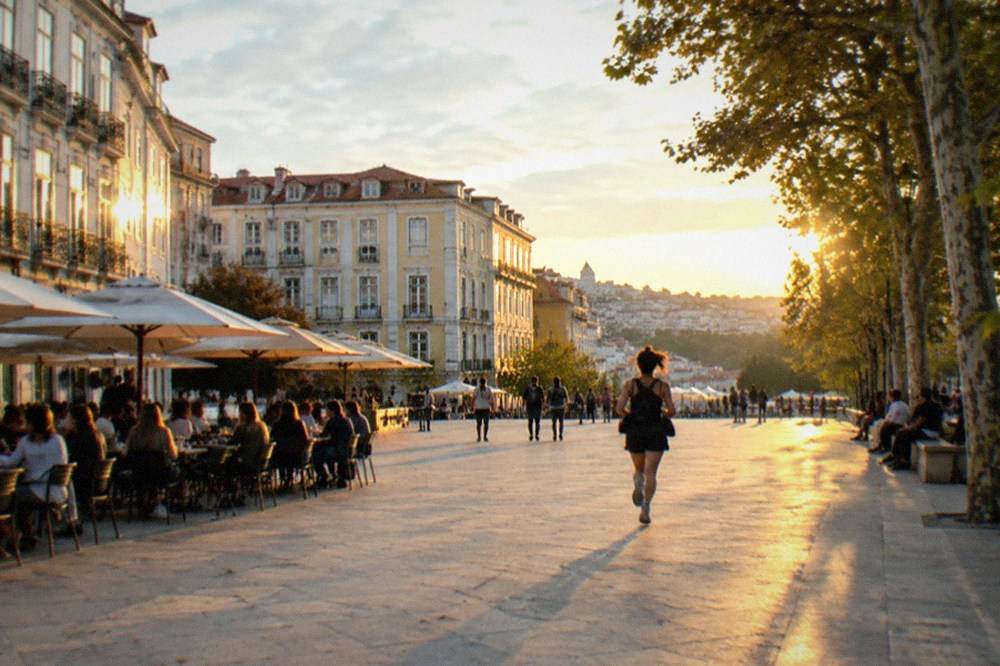 Students and visitors filling a cafe terrace on Praça da República in Coimbra in the early evening