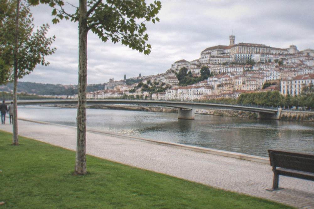 The River Mondego flowing past Coimbra with the old town and university buildings on the hillside above