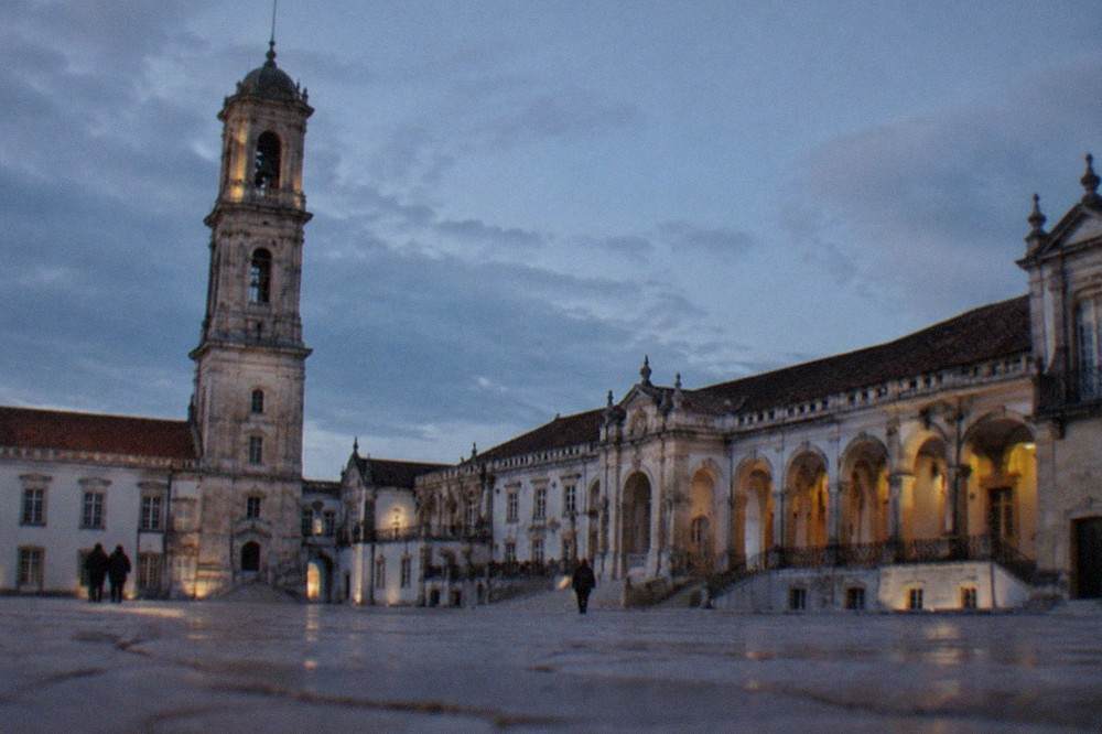 The courtyard of the Paço das Escolas at the University of Coimbra with its stone arcade and clock tower