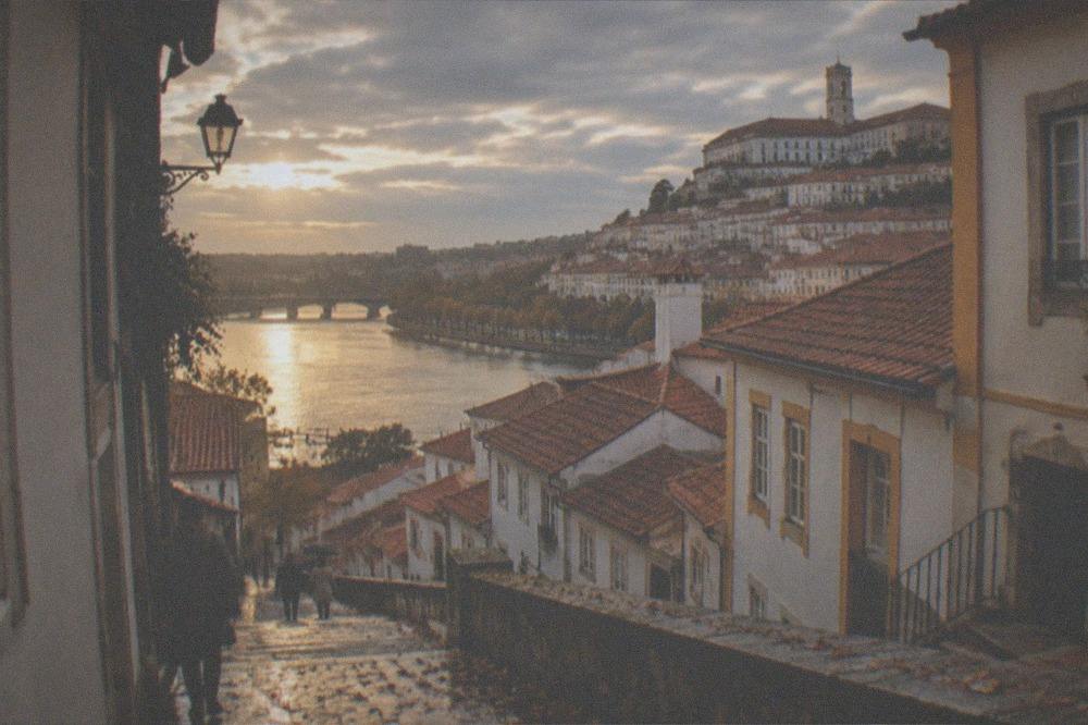 Warm late-afternoon light on the rooftops and river of Coimbra in early autumn