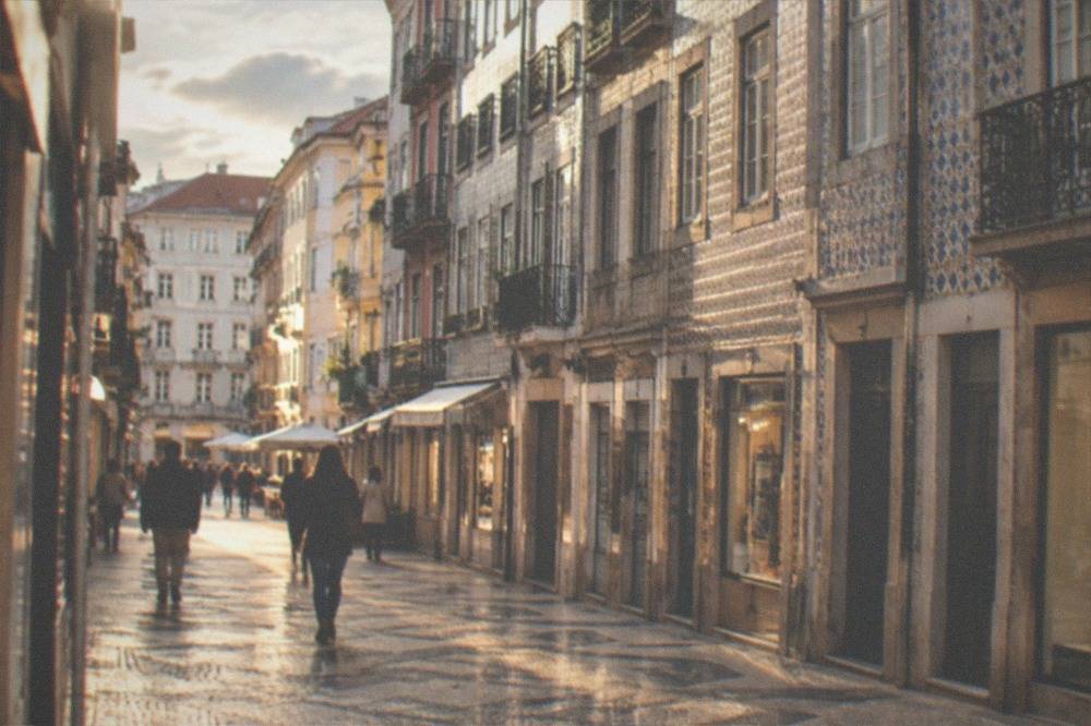 A pedestrian shopping street in Coimbra's Baixa with old shopfronts