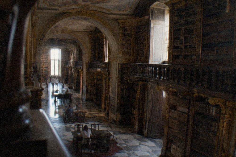 The baroque interior of the Biblioteca Joanina with its gilded bookshelves under painted ceilings