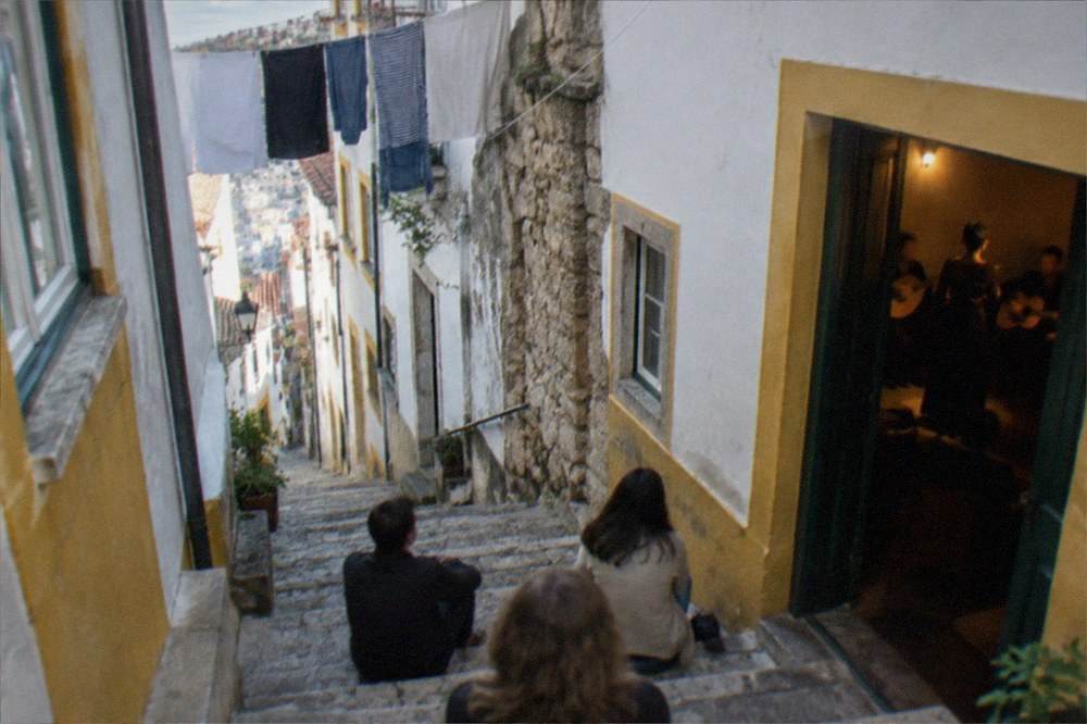 An evening fado performance with a singer and guitarists in a small dimly lit room