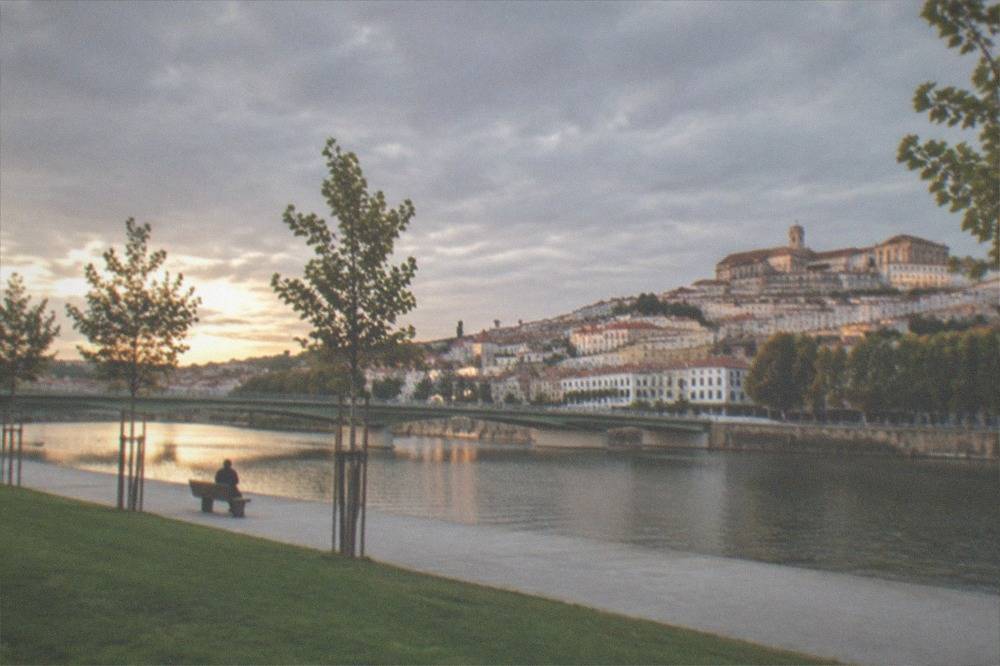 The old town of Coimbra in warm evening light with the River Mondego below