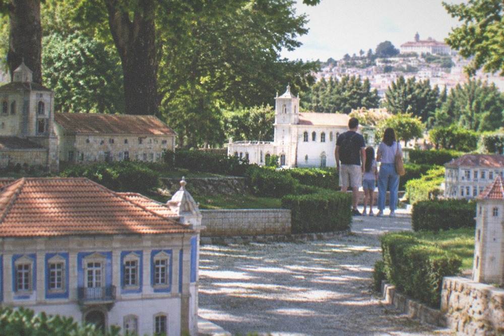 A family looking at the miniature buildings at Portugal dos Pequenitos