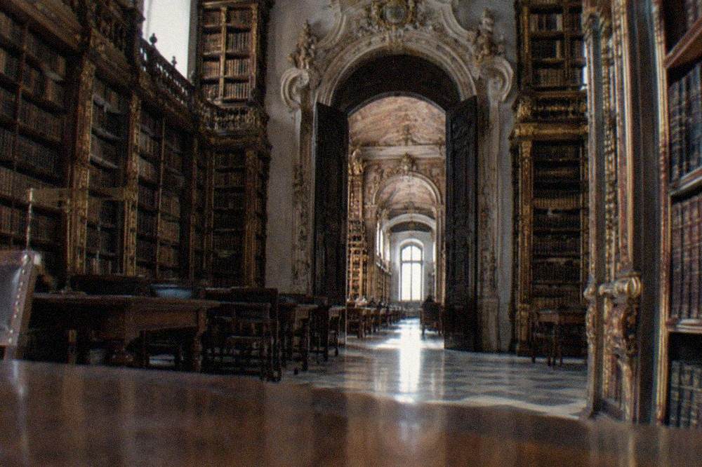 The grand baroque doorway of the Joanina Library with its stone carvings and dark wood doors