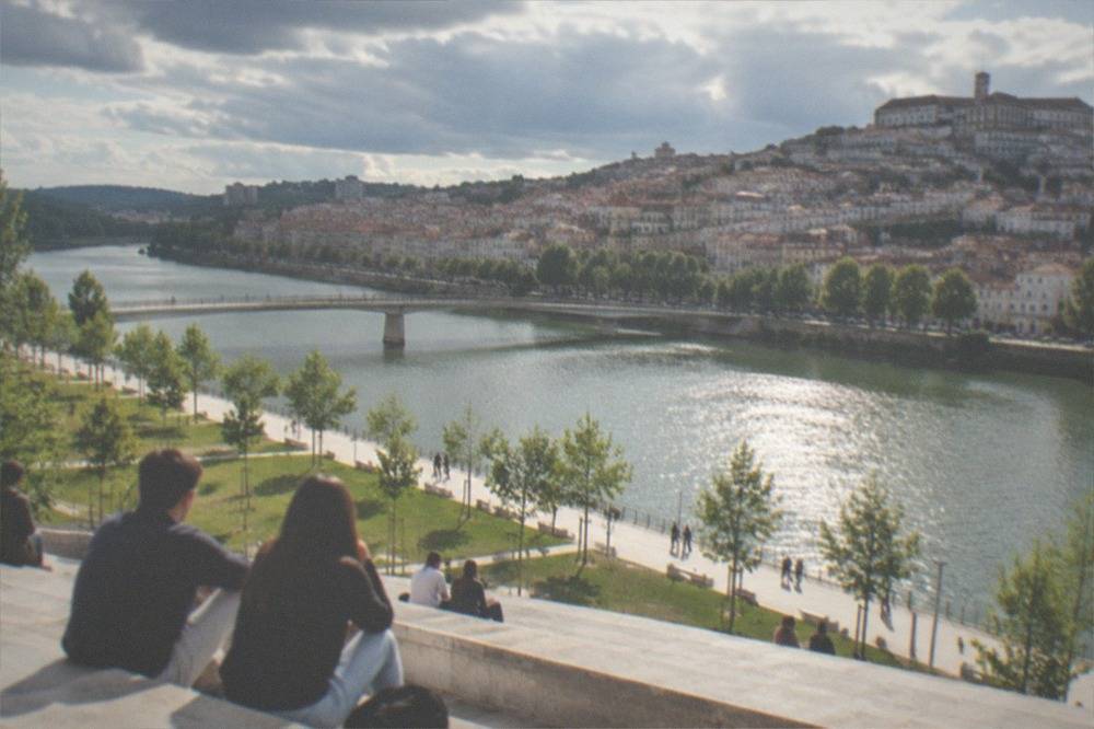 Students and visitors on the wide stone terrace overlooking the River Mondego from the university hill