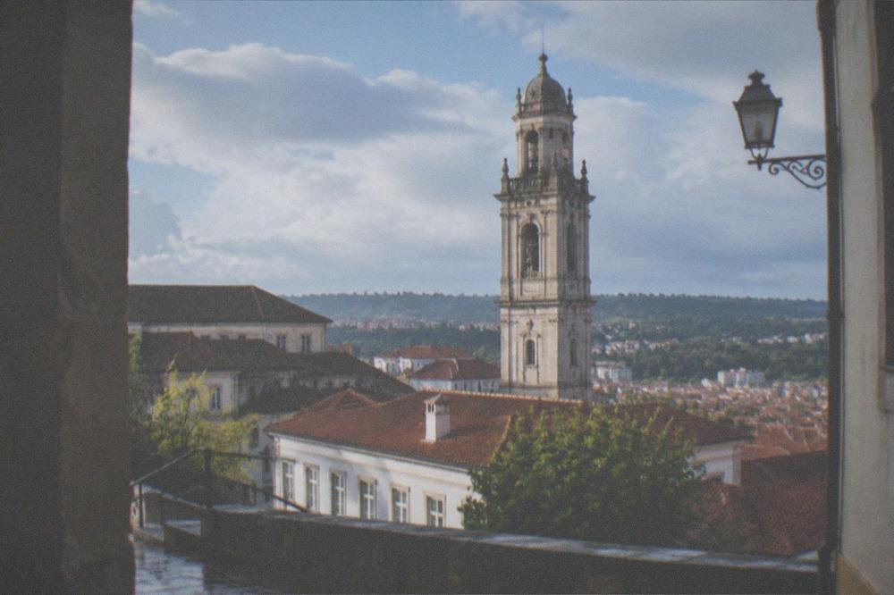 The historic clock tower rising above the rooftops of the University of Coimbra