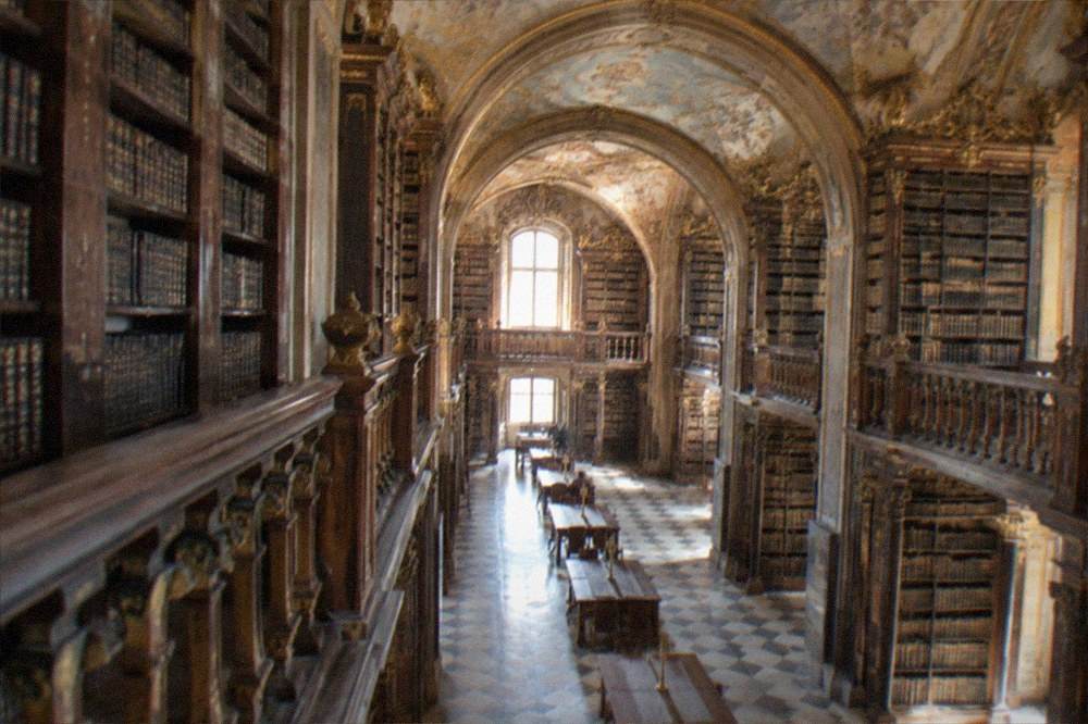 The baroque interior of the Joanina Library in Coimbra lit by warm daylight