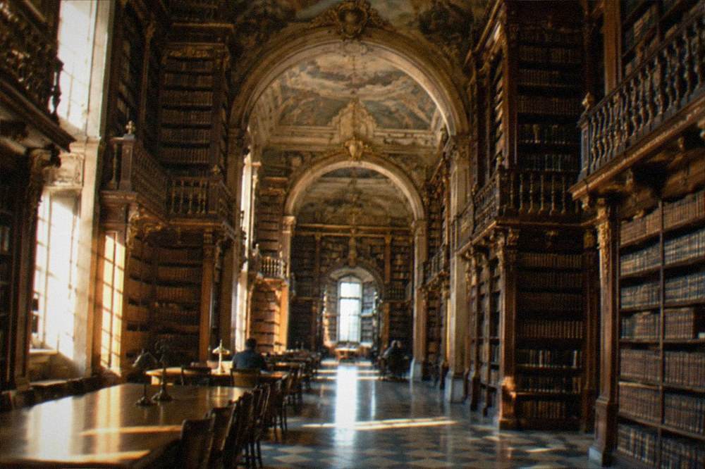 The baroque interior of the Joanina Library with tall wooden bookshelves
