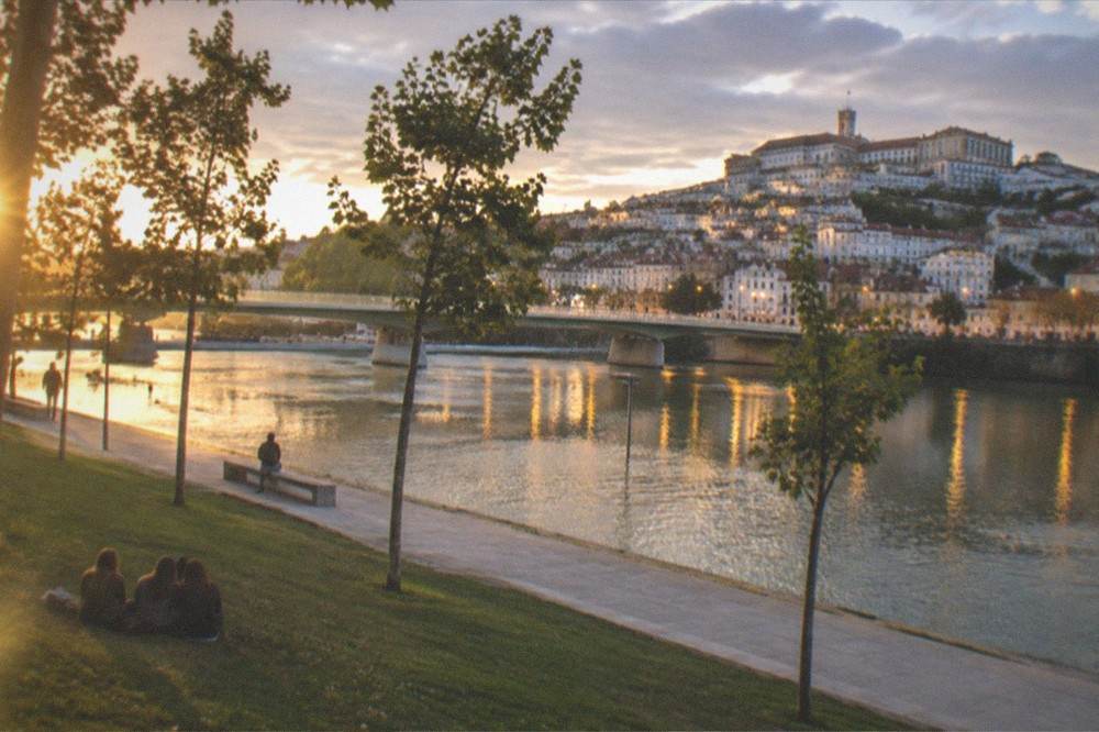 Evening lights of Coimbra old town reflected in the Mondego river