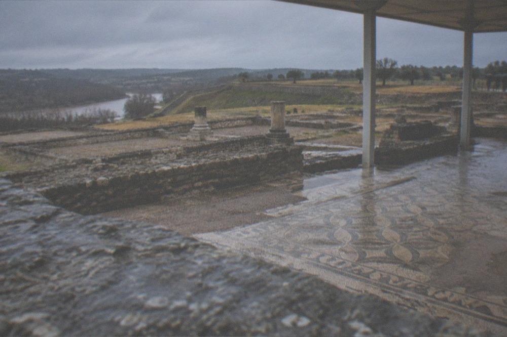 The Roman ruins of Conimbriga under a pale winter sky with column bases and mosaic floors