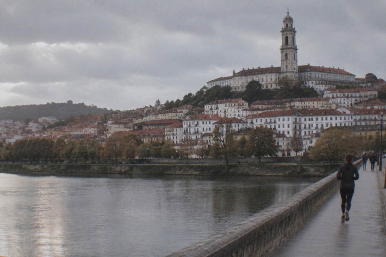 The hillside of Coimbra with the University tower rising above the red rooftops above the River Mondego