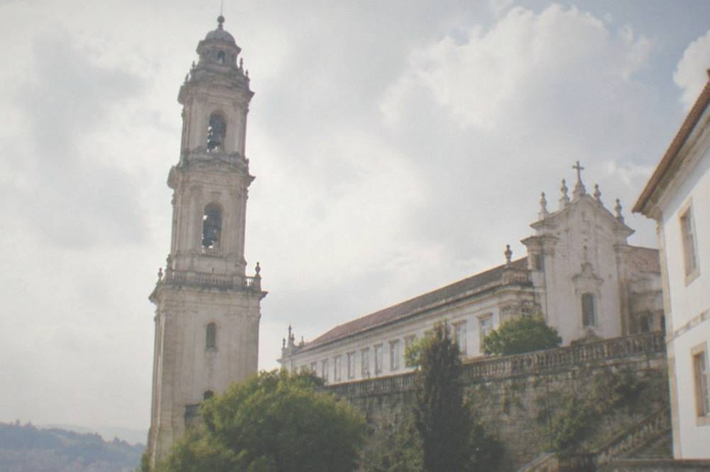The walled university courtyard with the clock tower and chapel facade above the city