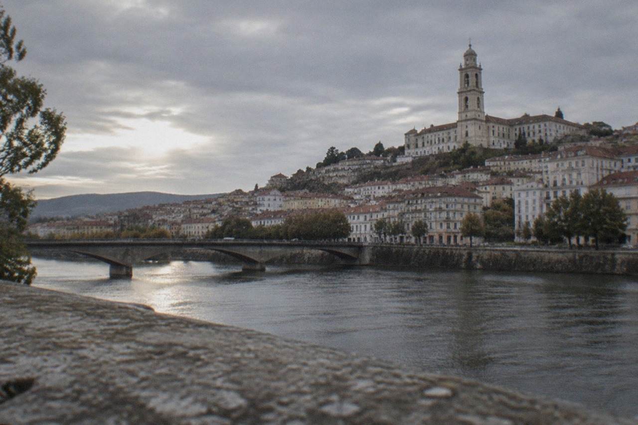 The old city of Coimbra rising above the River Mondego, with the university tower on the hilltop