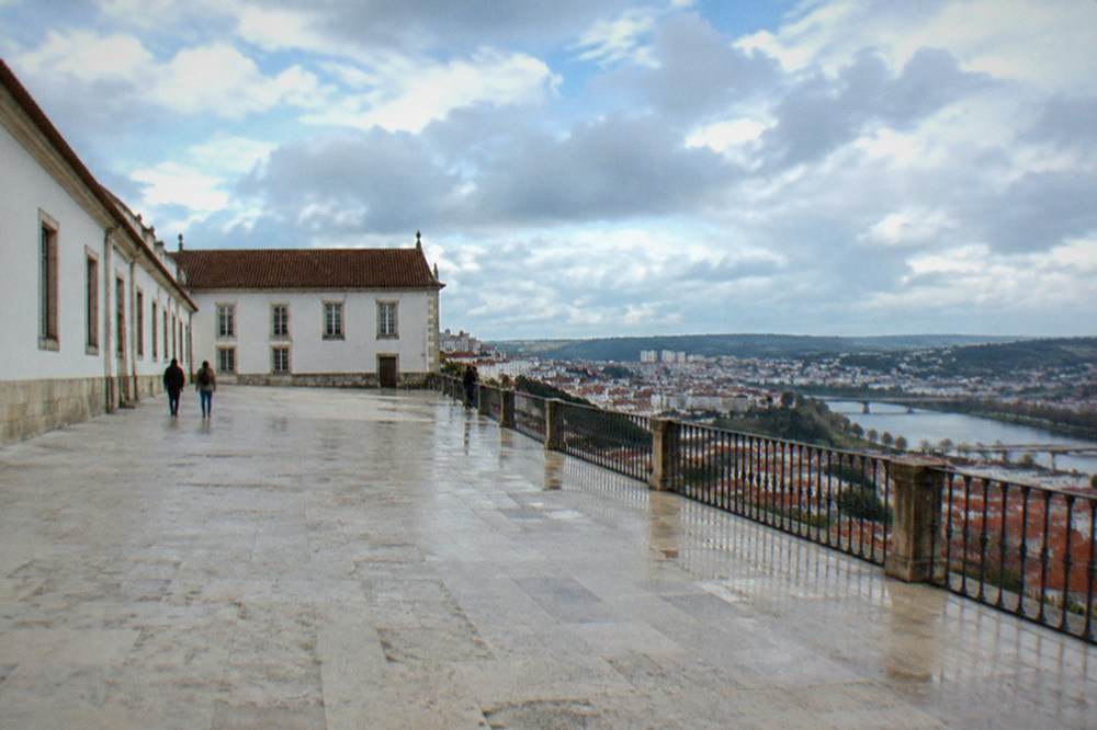 The wide stone courtyard of the Paço das Escolas with views over the red rooftops of Coimbra
