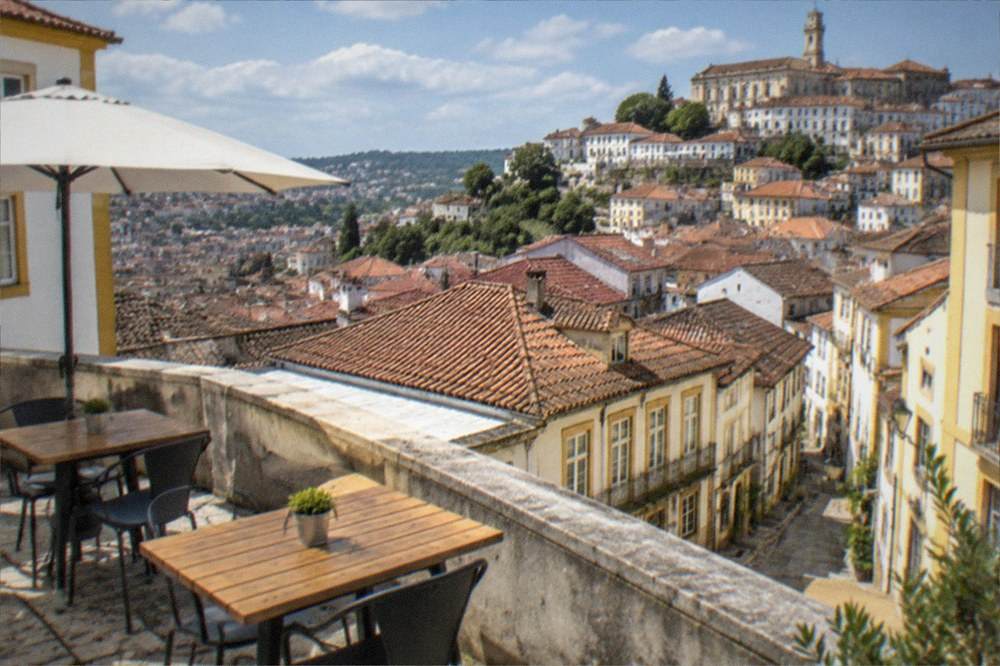 Sunlit terrace overlooking Coimbra old town on a clear warm day
