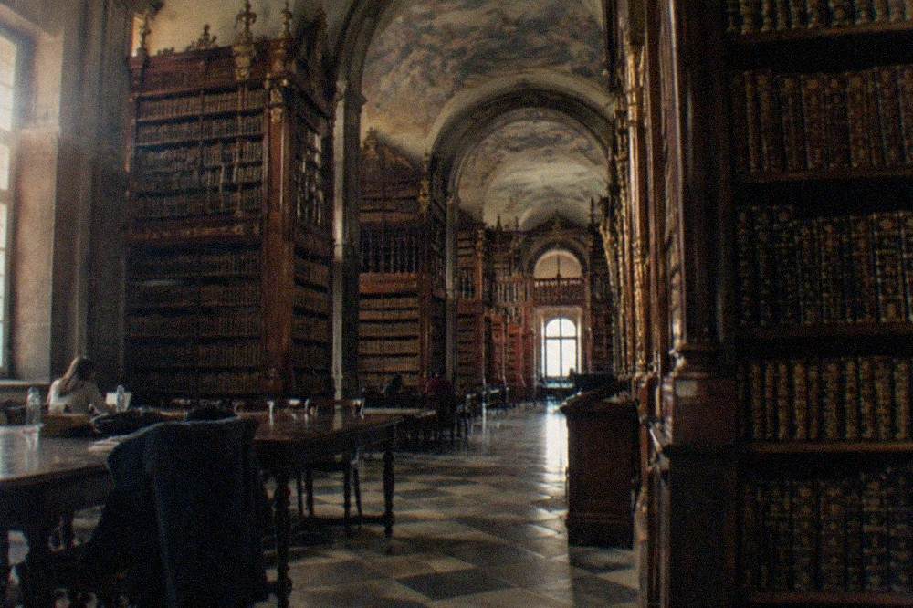 The baroque interior of the Joanina Library with its tall wooden bookshelves and painted ceiling