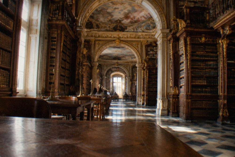 The baroque interior of the Biblioteca Joanina with its gilded bookshelves and painted ceiling